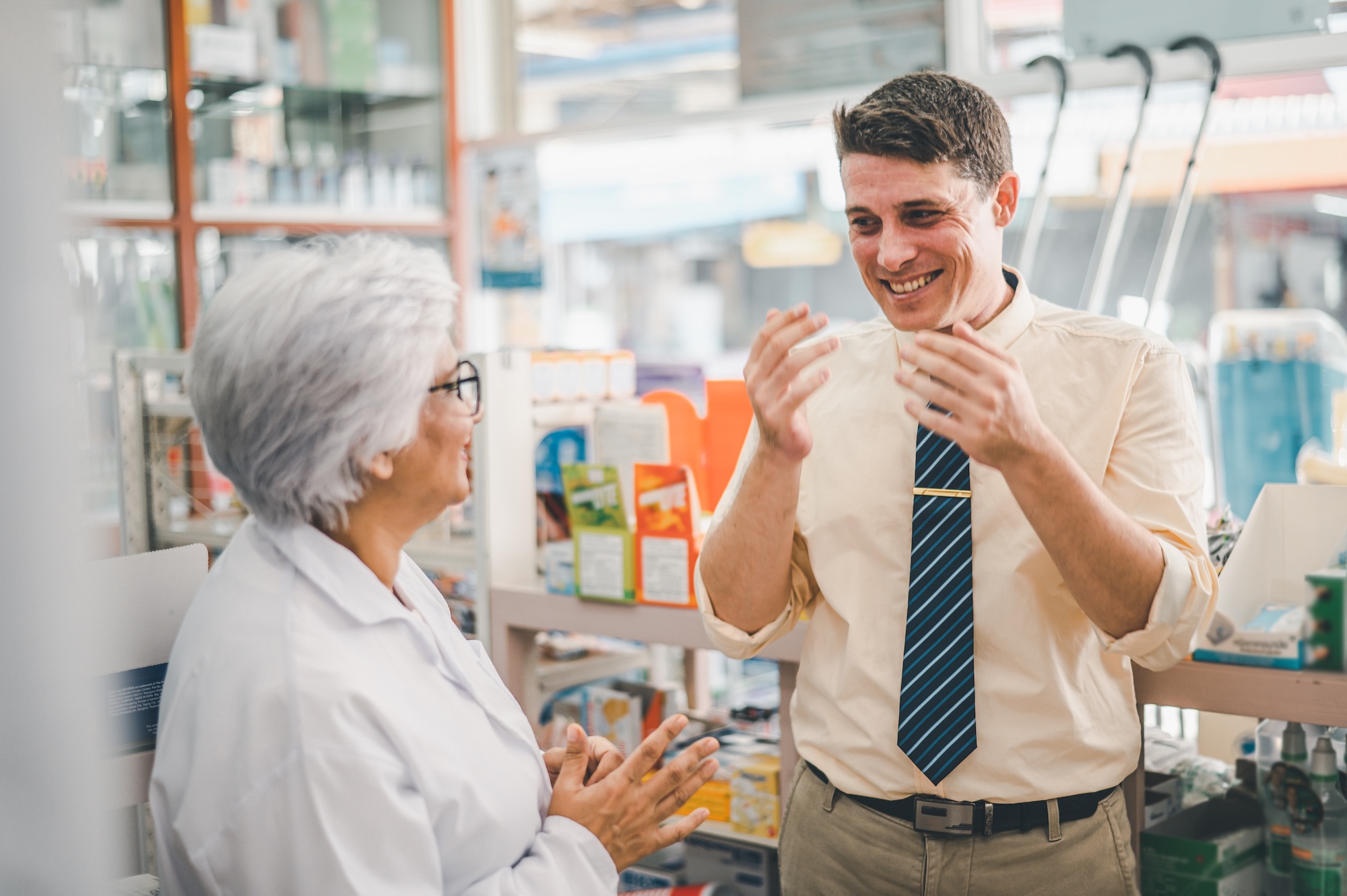 pharmacist is asking about a patient's condition in order to prescribe medication according to the patient's symptoms who come for prescription consultation in a modern pharmacy.